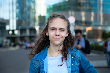 Young girl smiles and looks at the camera on the street