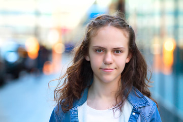 Young girl smiles and looks at the camera on the street