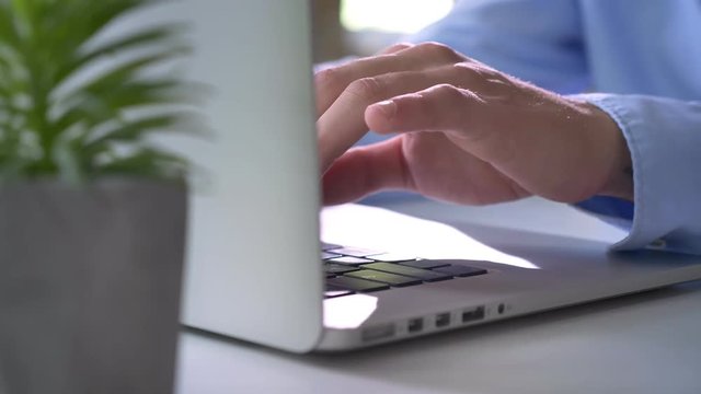 Close footage of programmer hands typing on laptop