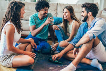 Group of young friends playing game of truth. Home party.