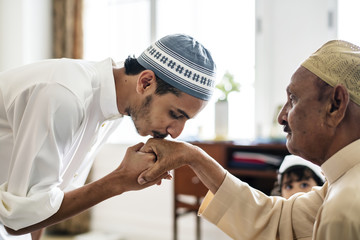 Young Muslim man showing respect to his father