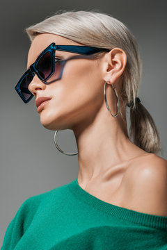 stylish woman in sunglasses looking away isolated on grey background