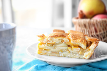 Plate with piece of delicious apple pie on table