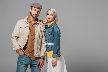 beautiful couple of models posing in autumn outfit, isolated on grey