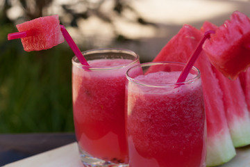 Watermelon drink in glass with slices of watermelon