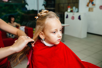 Cute little girl in hairdressing salon