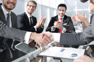 handshake business partners over the Desk