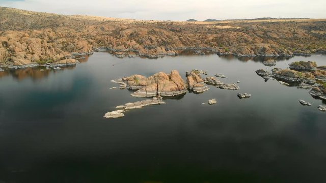 Aerial view of watson lake from one side to another. Showcasing granite dell rock formation and a lone kayaker in lake water on sunny day