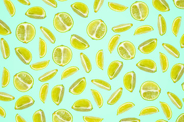 Isolated lime pattern or wallpaper on turquoise green background. Summer concept of fresh ripe lime liths and slices shot from above