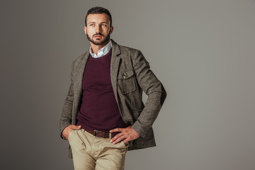 elegant stylish man posing in autumn tweed jacket, isolated on grey