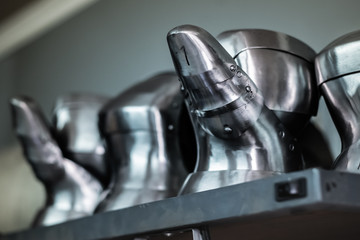 Professionally built metal gauntlets in a workshop. Close-up image of assembled and partially finished medieval armour suit details.