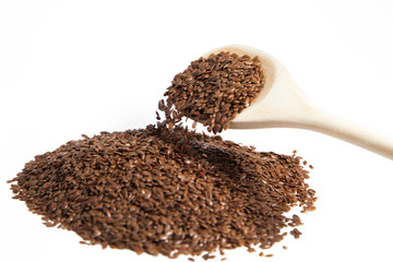 Flax seeds in a wooden spoon on white isolated background