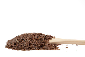 Flax seeds in a wooden spoon on white isolated background