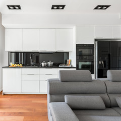 Gray sofa and white kitchen
