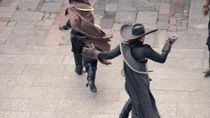 Top view, a musketeer in black clothes fights off two opponents