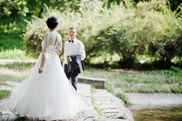 Young newlyweds walking in the park on their sunny wedding day.