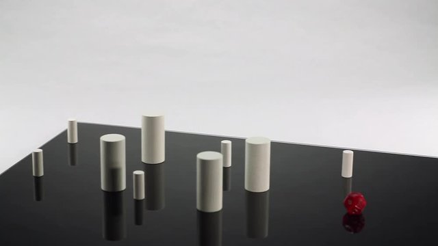 wooden pillars and a die on a rotating black glassplate