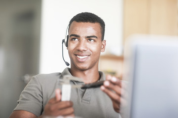 Junger Mann mit Messinstrument an einem Schreibtisch