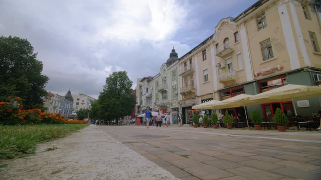 Timelapse of a busy promenade with cafes and pedestrians