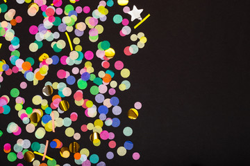 Colorful confetti on black background with copy space