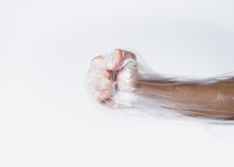 male fist struggling against transparent plastic bag