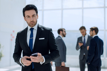 businessman with a smartphone on background office