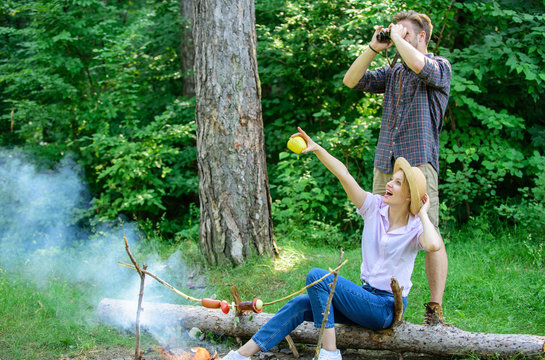 Couple enjoy hike in forest observing nature. Couple ornithologists expedition in forest. Woman and man looking binoculars near bonfire. Observing nature concept. Ornithology interesting occupation