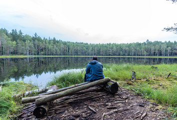 A fisherman is fishing on a forest lake
