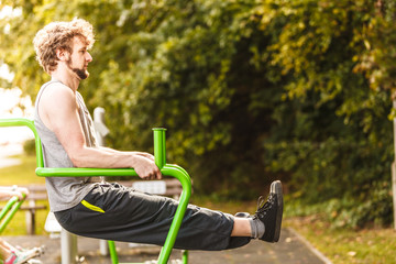 Active man exercising on leg raise outdoor.