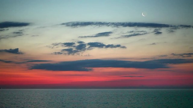 passing a moon over the sea