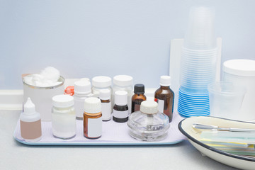 Different medical bottles on white metal plate on table. Copy space. Empty place for text or logo.