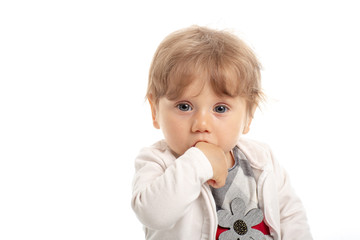 Elegant baby girl 1 year old sitting on the studio floor. White Background.