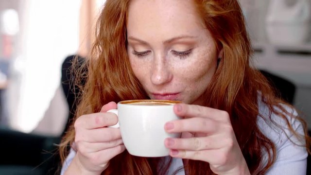 Young Woman Drinking Coffee At Cafe