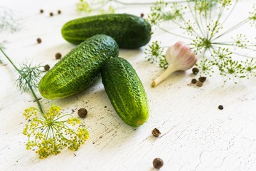cucumbers, vegetable herbs and spices on a white old wooden table