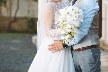 Groom Hugging Bride with Bouquet