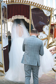 Groom Helping Bride in Carriage