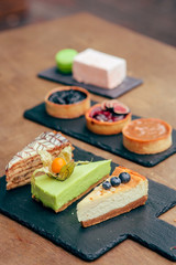 served tableful with little cakes, pie and beverages at kids birthday