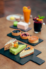 served tableful with little cakes, pie and beverages at kids birthday