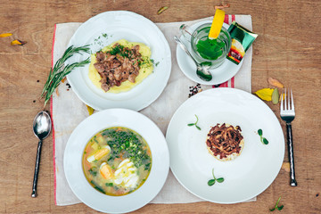 full dinner for one person with few dishes at wooden background