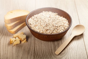 Raw oats in bowl and bread