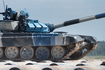 Military armored tank driving in mud at the open field