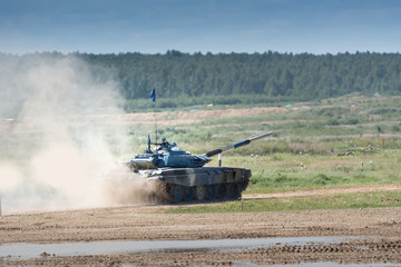 Military armored tank driving in mud at the open field