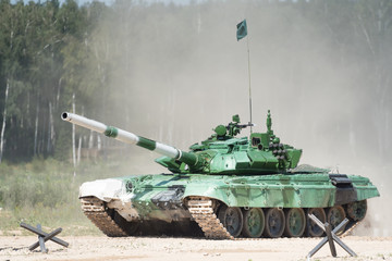 Military armored tank driving in mud at the open field