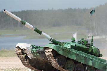 Military armored tank driving in mud at the open field