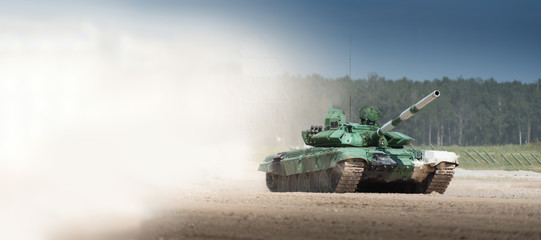 Military armored tank driving in mud at the open field. copyspace