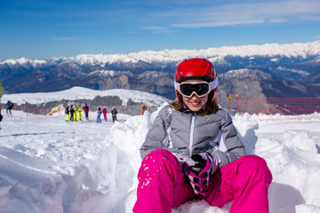 Fototapeta na wymiar Happy little girl sitting in the snow