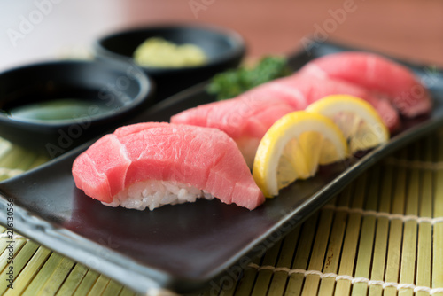 Otoro Tuna Sushi On Black Plate Along With Japanese Sauce And