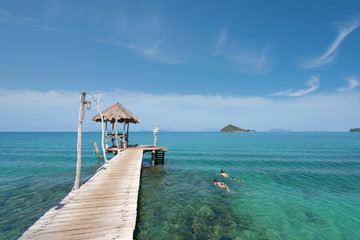 Young couple of tourists snorkel in crystal turquoise water near tropical resort in Phuket, Thailand. Summer, Vacation, Travel and Holiday concept.