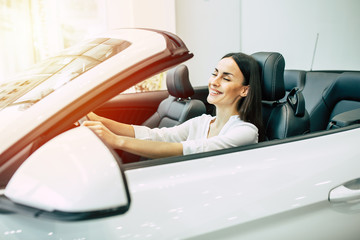 Gorgeous woman buying a new car for job and travel in dealership, girl customer