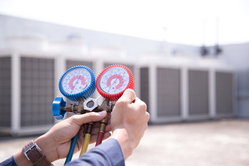 Technician is checking air conditioner ,measuring equipment for filling air conditioners.